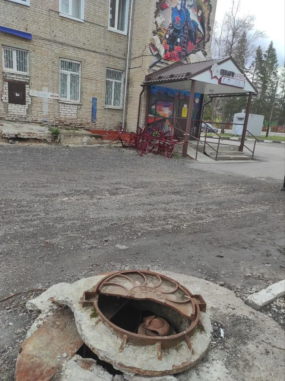 Парапет упал с недавно отремонтированной крыши, фасад прикрыт сайдингом, а за ним здание разрушается. Жители также жалуются на открытые люки и халтурный ремонт дорог — на фоне низких рейтингов местных властей.