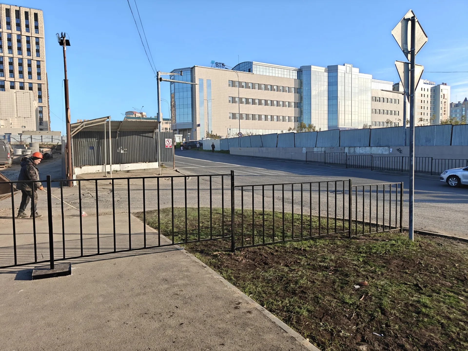 Ограждения перекрыли тротуары в центре города, и пешеходам приходится обходить стройплощадку по проезжей части; ранее подобная ситуация возникала на другой стройке.